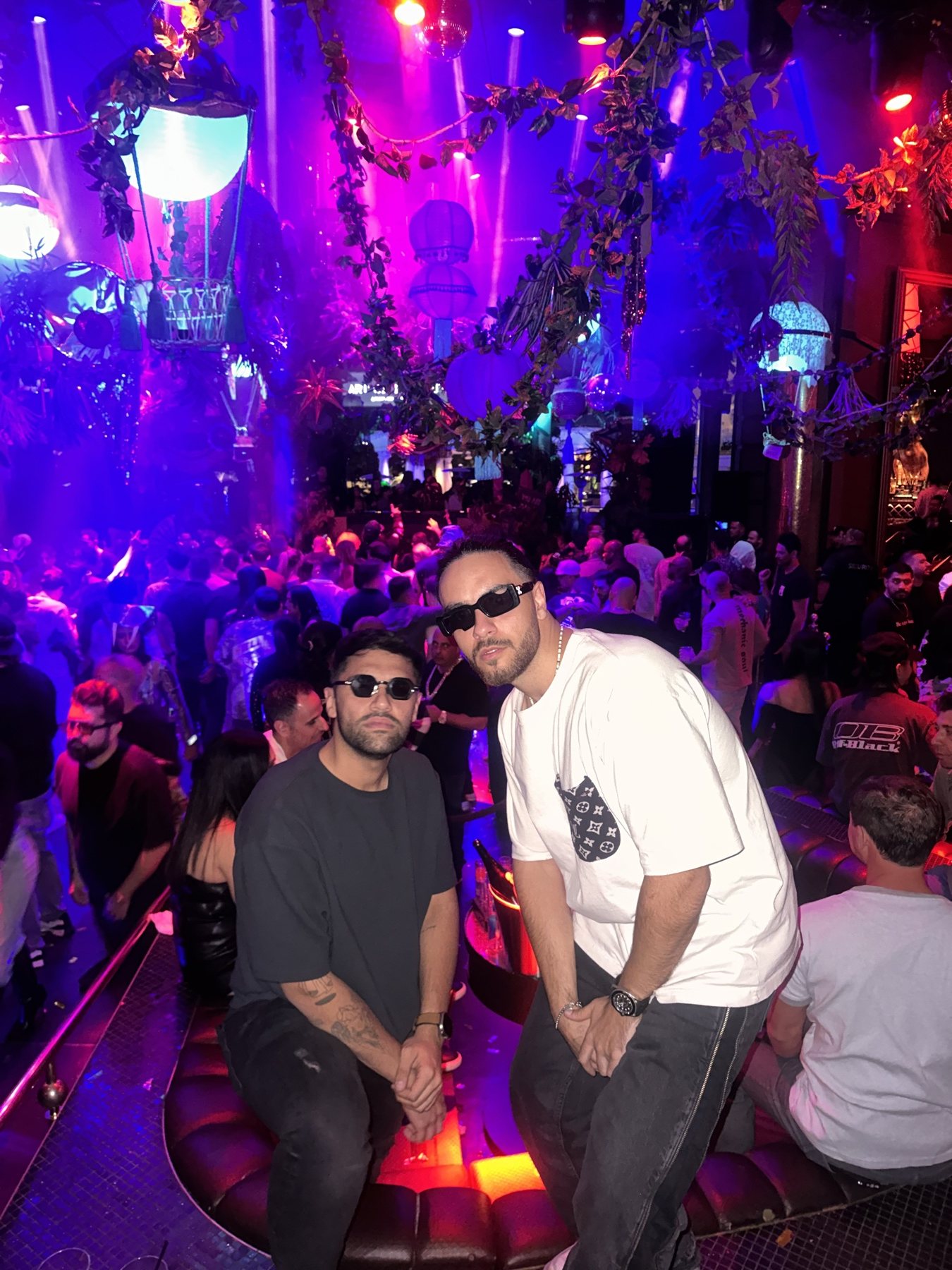 DOSO and Mehrad in sunglasses in front of a packed club floor under pink and blue lights